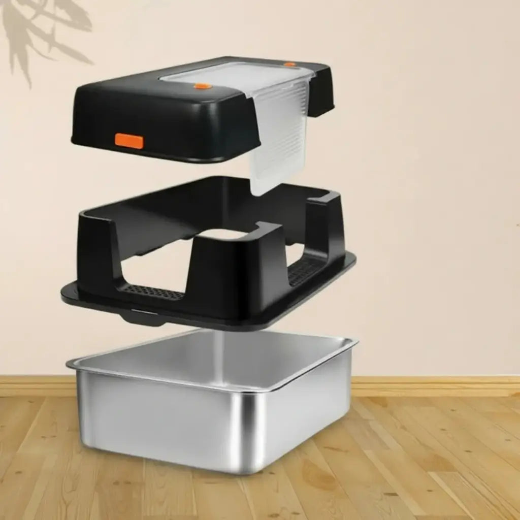 Black plastic litter box parts with a metal platform on a wooden floor