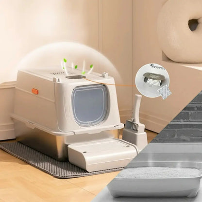 Pet litter box with scoop and mat on a wooden floor