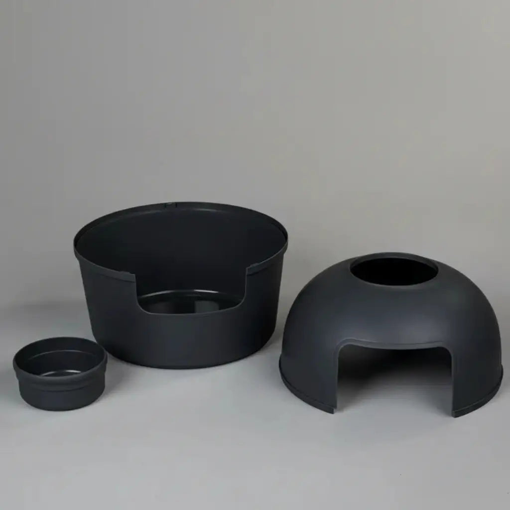 Set of three black plastic parts of a litter box on a gray background