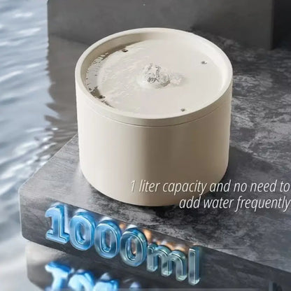 White cylindrical water fountain with water flowing, placed on a dark surface with '1000ml' text